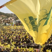 Des milliers de personnes brandissant des drapeaux libanais et des drapeaux jaunes du Hezbollah.